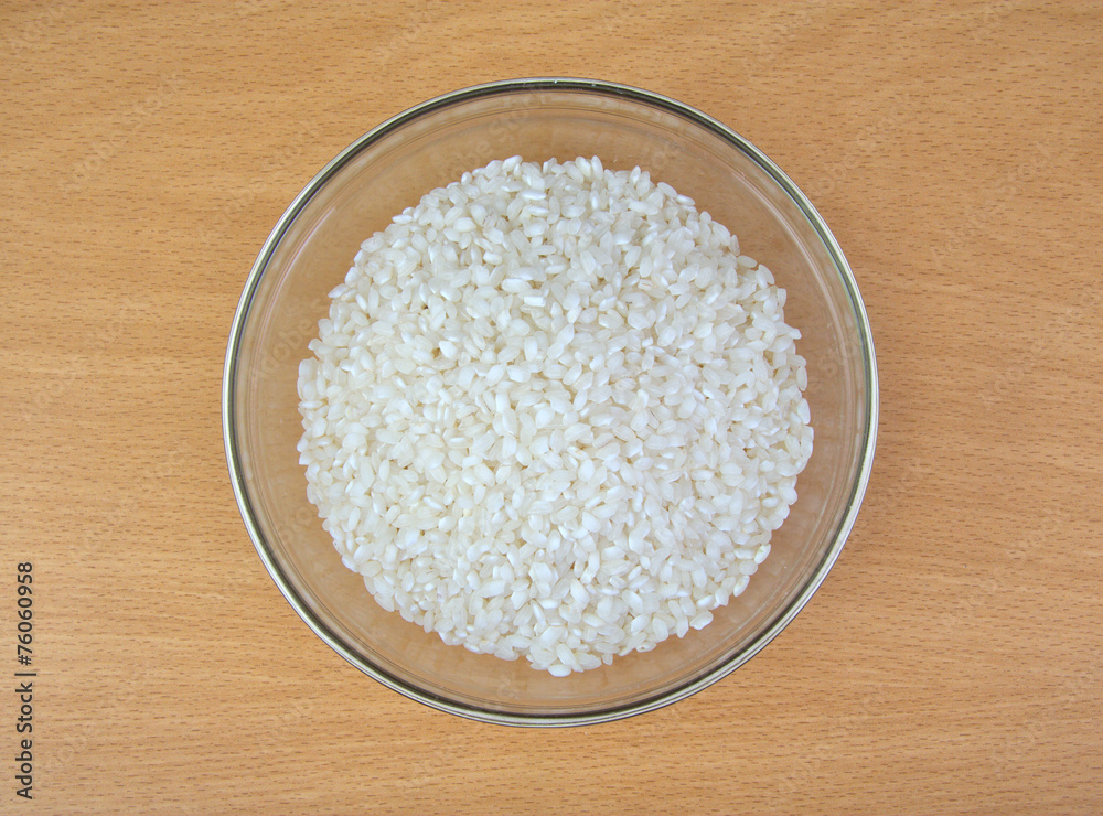 White dry uncooked rice in bowl on wooden background. White dry uncooked rice in bowl on wooden background.