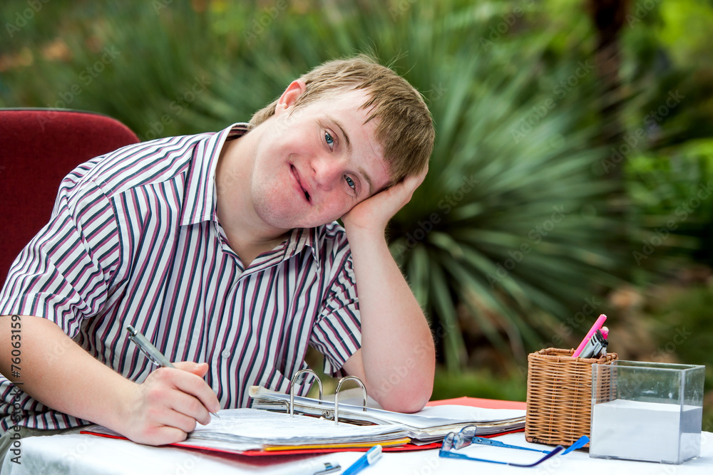 Handicapped boy resting on hand at desk. Handicapped boy resting on hand at desk.