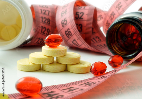 Measuring tape and bottle with pills. supplements of diet