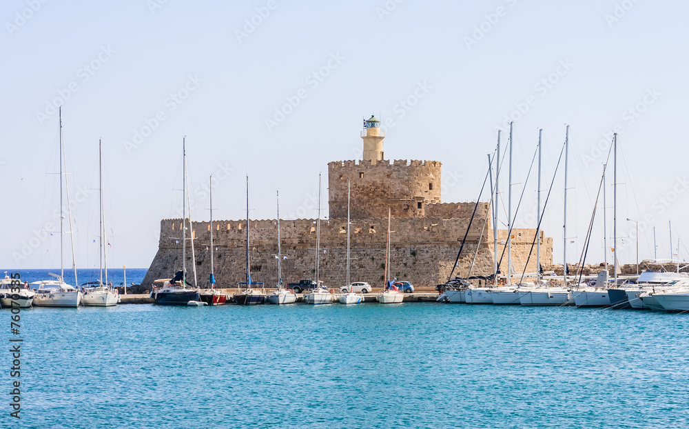 Sailing yacht in the port of Mandraki on the background of the o