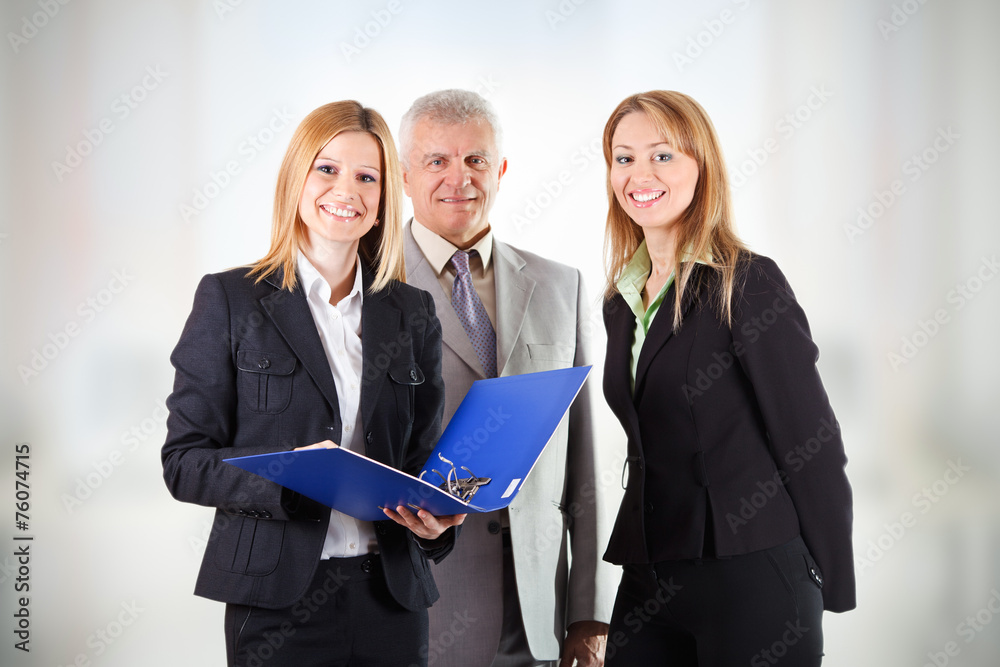 Three smiling business people standing in office Three smiling business people standing in office