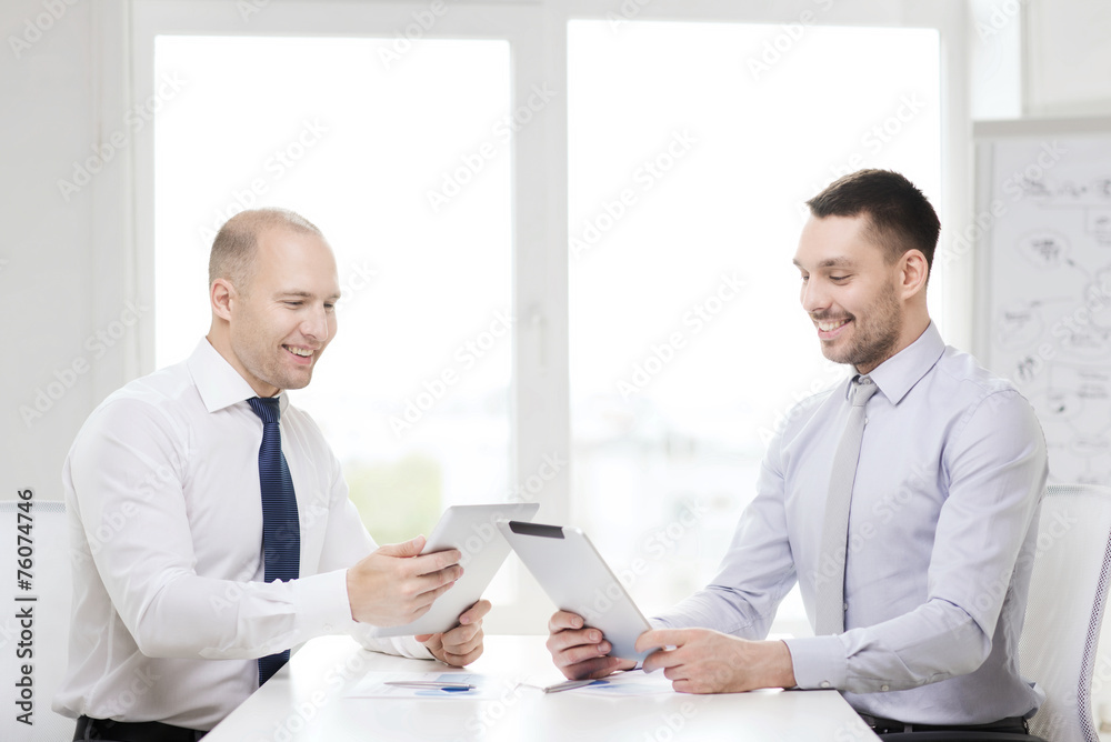 two smiling businessmen with tablet pc in office two smiling businessmen with tablet pc in office