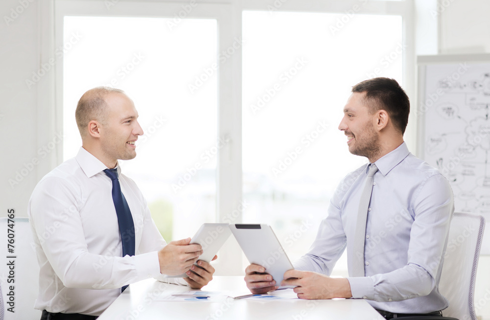 two smiling businessmen with tablet pc in office two smiling businessmen with tablet pc in office