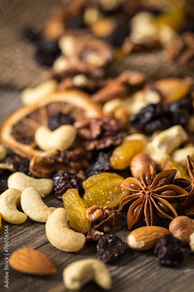 Close-up of nuts and dried fruits mix on wooden surface.