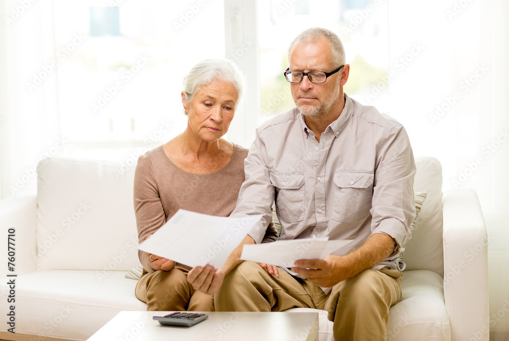 senior couple with papers and calculator at home