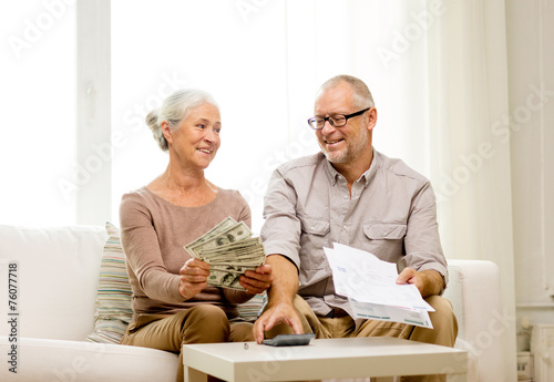 senior couple with money and calculator at home