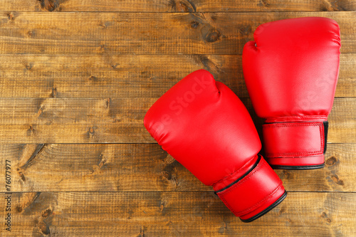 Pair of boxing gloves on wooden planks background