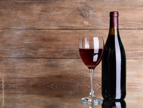 Red wine on table on wooden background