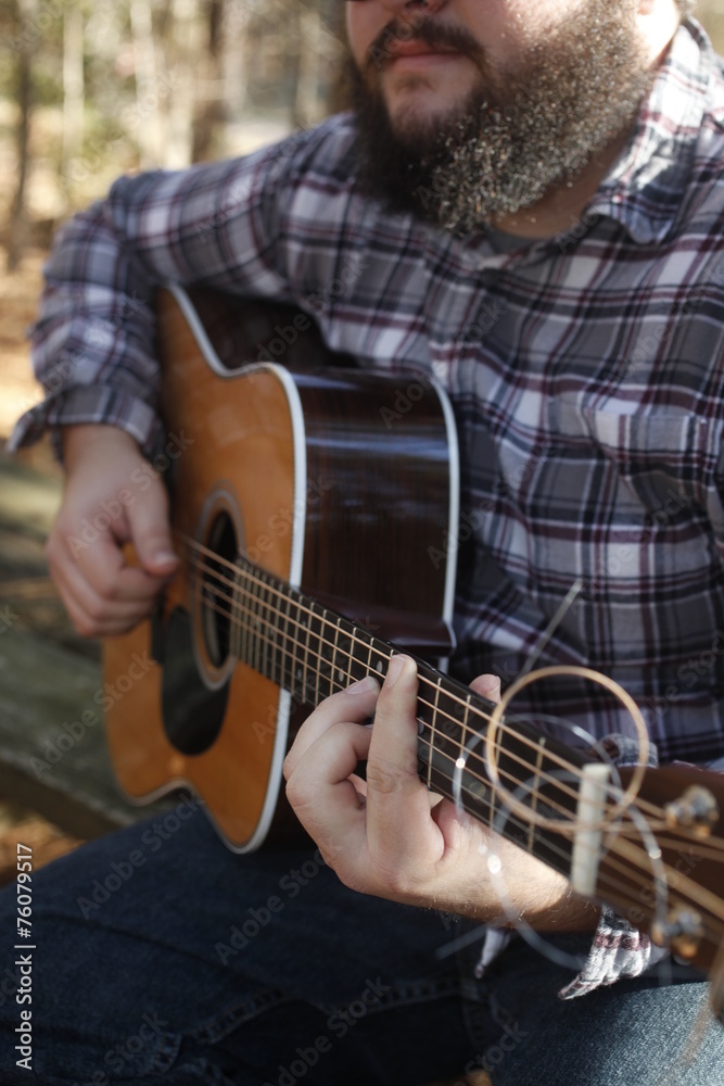 Obraz premium A folk country musician playing his guitar.