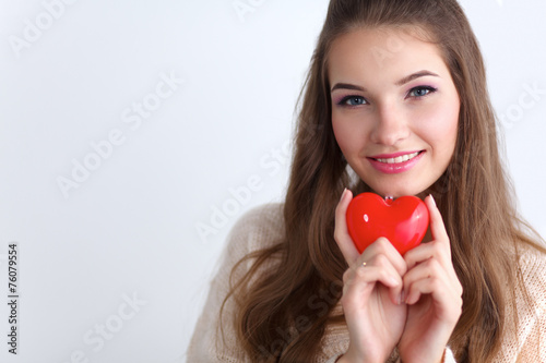 Portrait of beautiful happy woman holding a symbol heart.