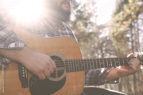 A folk country musician playing his guitar. photo