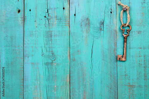 Skeleton key hanging on teal blue wood door