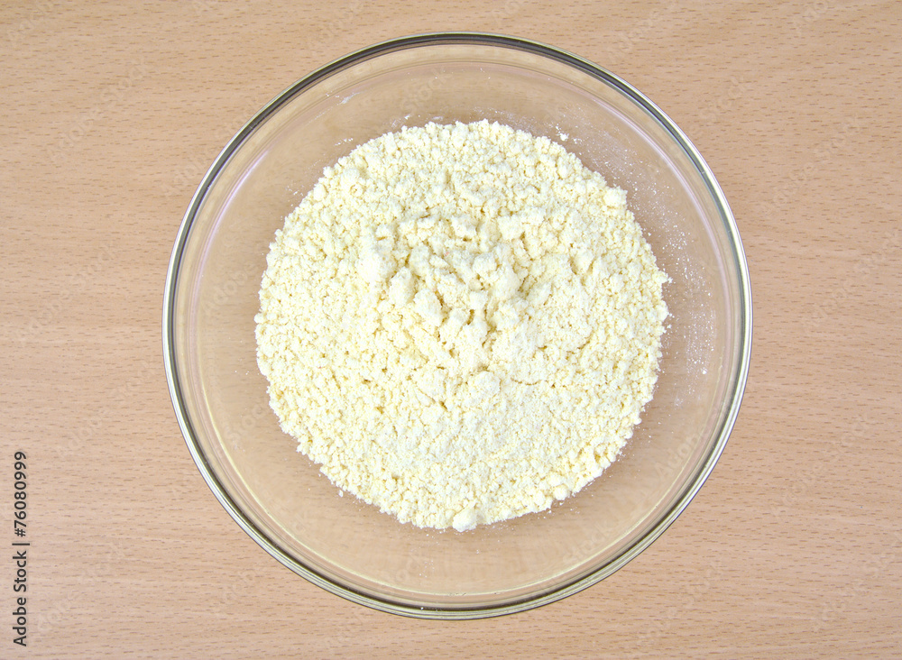 Cornflour in a glass bowl on wooden background. Cornflour in a glass bowl on wooden background.