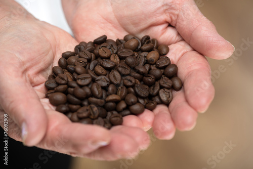 Elderly woman holding coffee beans