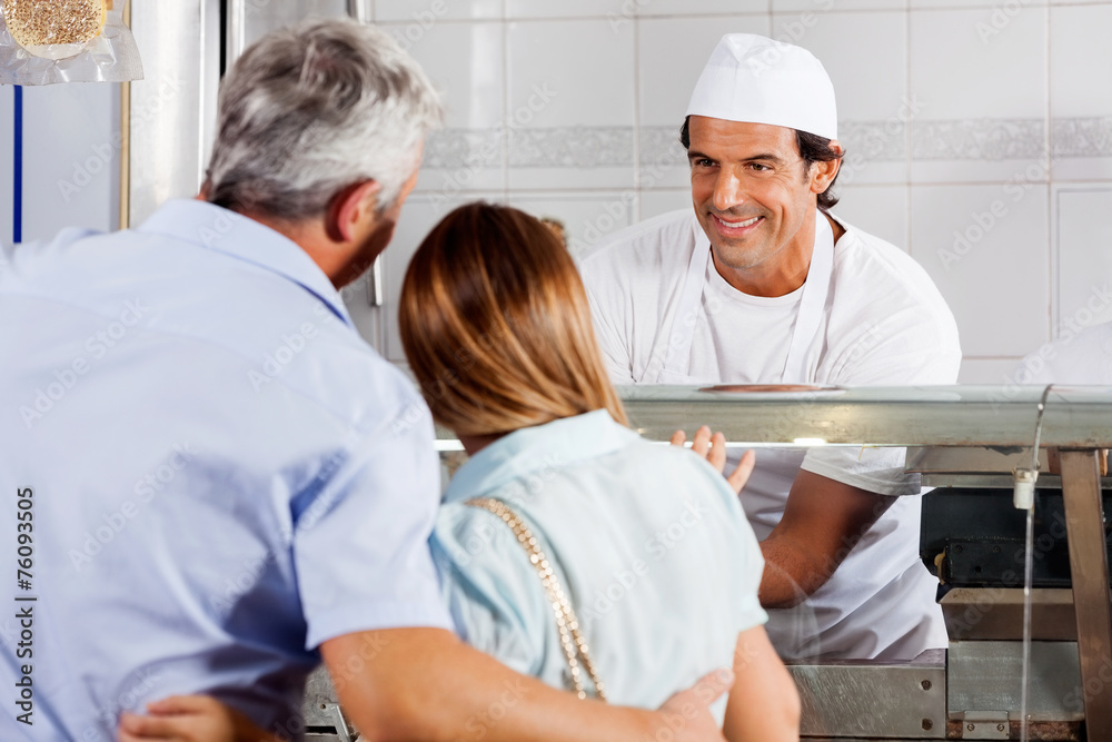 Fototapeta premium Butcher Looking At Customers In Shop