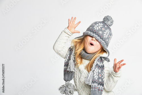 Piękna blond dziewczyna bawić się w zima ciepłym kapeluszu dalej i szaliku