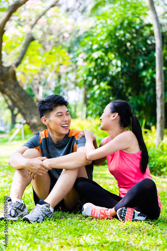 Asian couple having break at during sport training