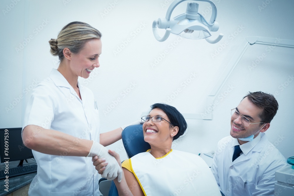 Female dentist shaking hands with woman Female dentist shaking hands with woman