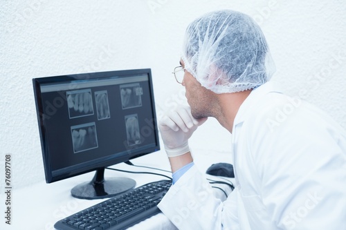 Dentist looking at x-ray on computer