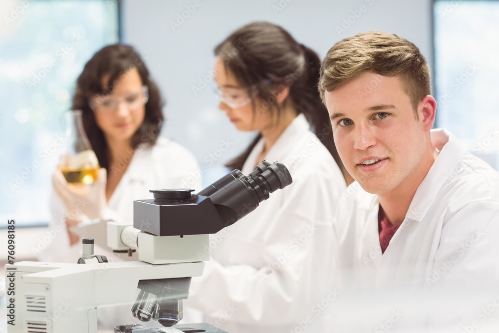 Science student looking through microscope in the lab Science student looking through microscope in the lab