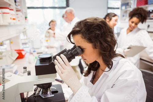 Science student looking through microscope in the lab