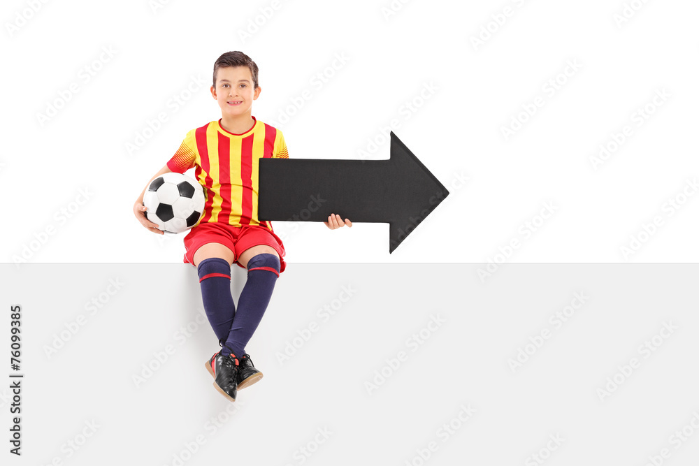 Junior athlete holding an arrow and a football Junior athlete holding an arrow and a football