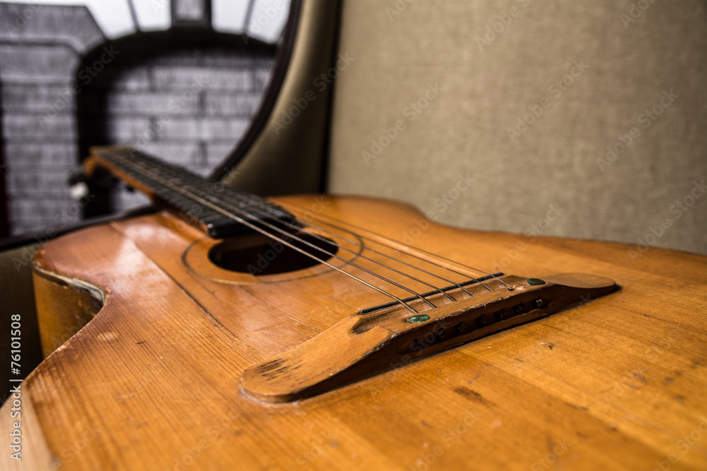 Close-up of acoustic guitar lying on the sofa Close-up of acoustic guitar lying on the sofa