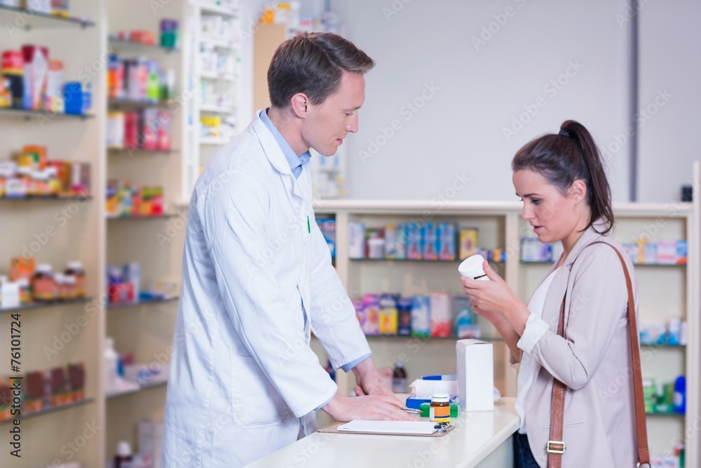 Customer talking to a pharmacist while holding a box of pills