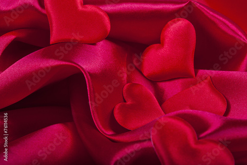 red heart Valentine's Day symbols on red silk background