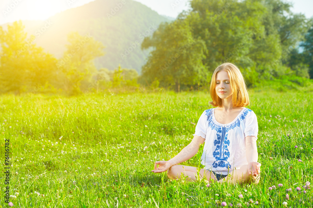 young woman doing yoga on green grass young woman doing yoga on green grass