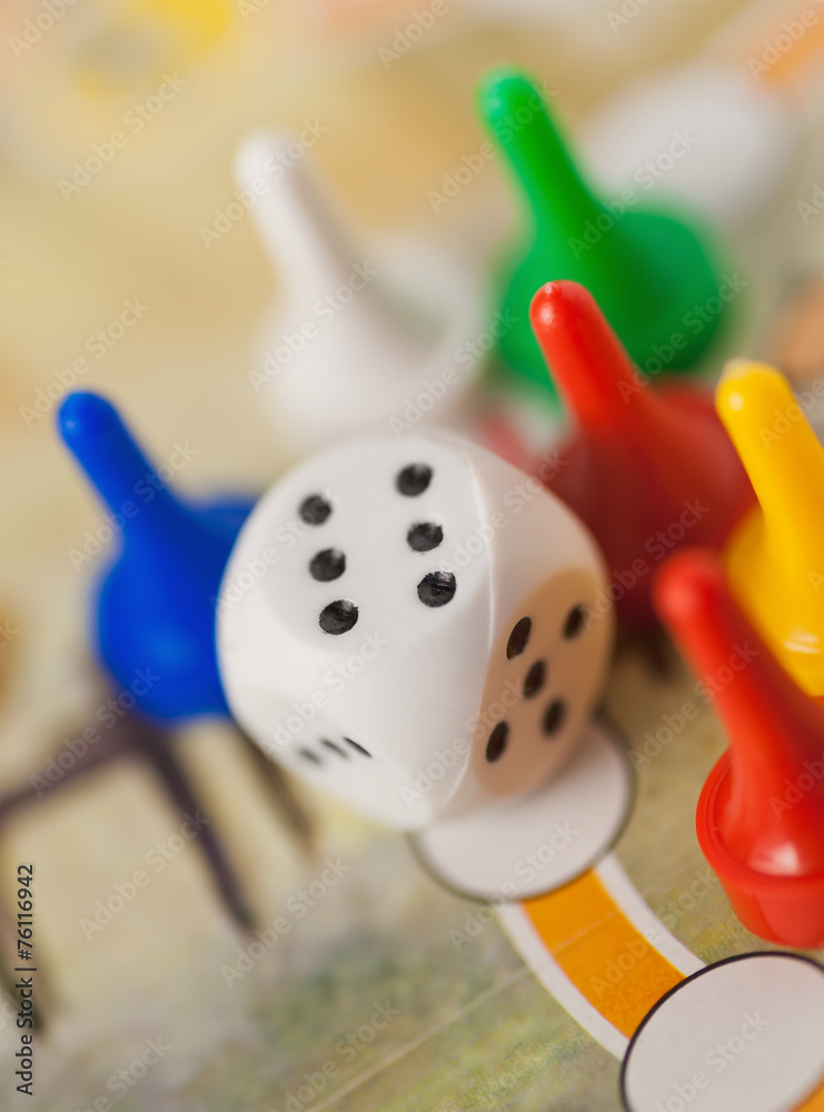 white dice cube near multicolored counter on game field white dice cube near multicolored counter on game field