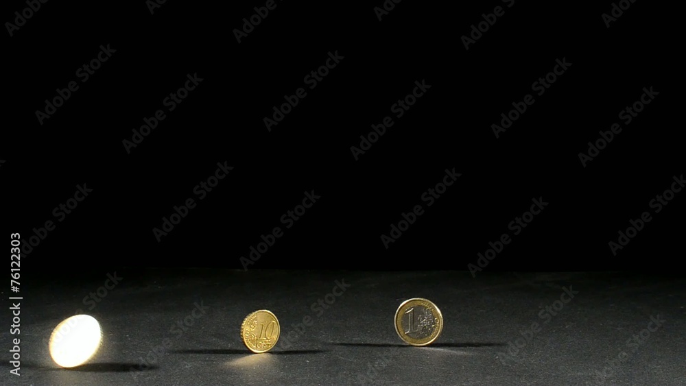 drei euro muenzen und eine in bewegung mit schwarzen hintergrund