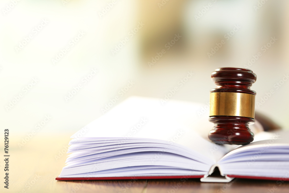 Wooden judges gavel lying on law book, close up Wooden judges gavel lying on law book, close up