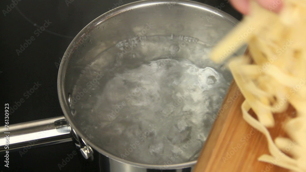 Pasta being added to a pot of boiling water.