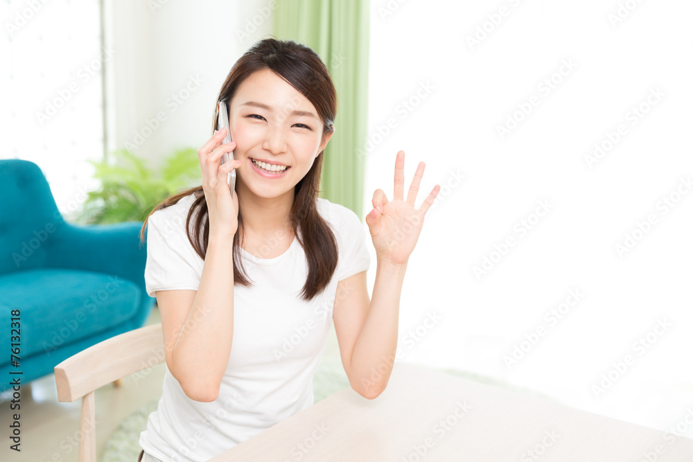 部屋で電話をする女性 部屋で電話をする女性