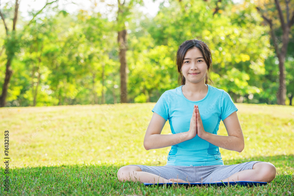 Asian woman doing yoga exercises outdoor in park