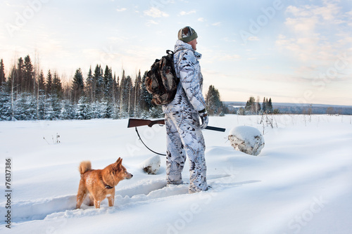 hunter with dog on the snowy road