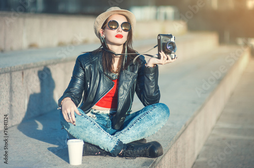 Young fashion beautiful girl in leather jacket with retro camera photo