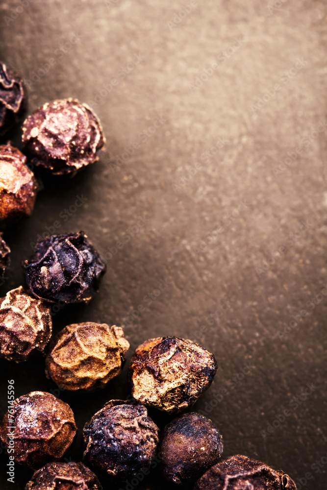 Black Peppercorns closeup. Black pepper on dark background with