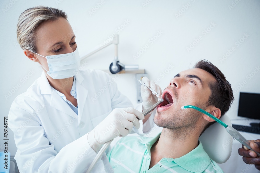 Female dentist examining mans teeth Female dentist examining mans teeth