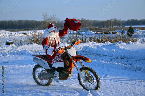 On a motorcycle motocross Santa Claus welcomes