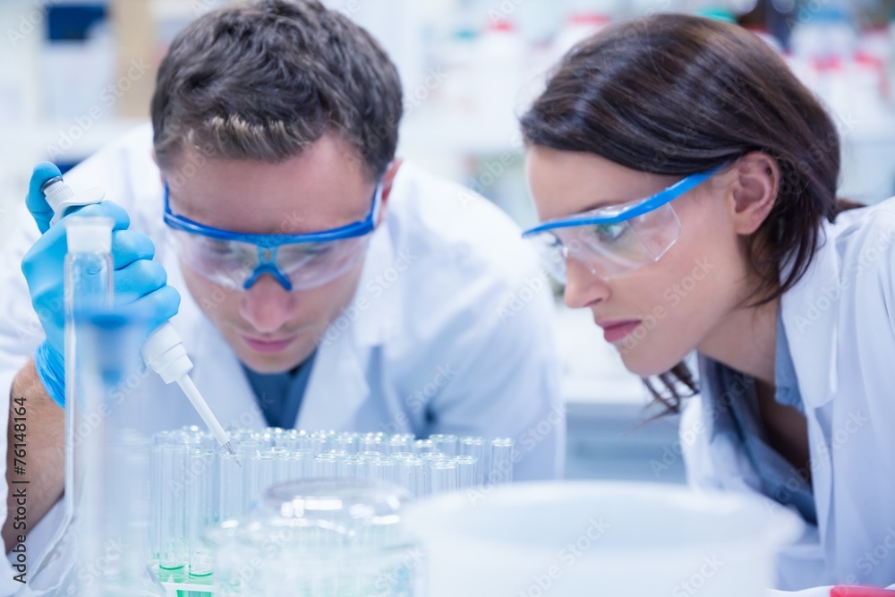 Chemist team working with pipette and test tube Chemist team working with pipette and test tube