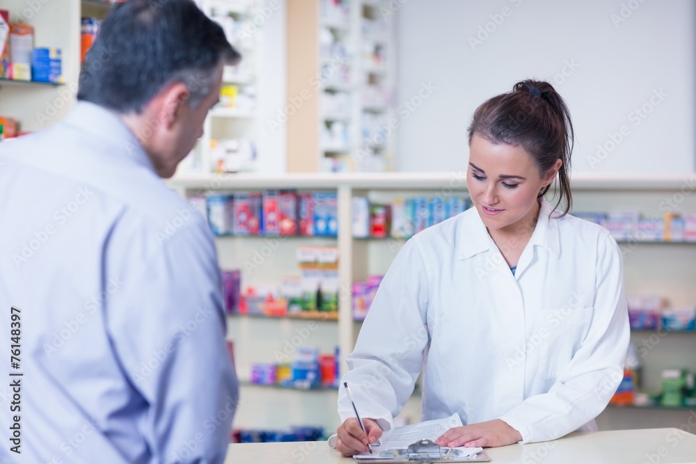 Fototapeta premium Trainee writing prescription in front of a customer