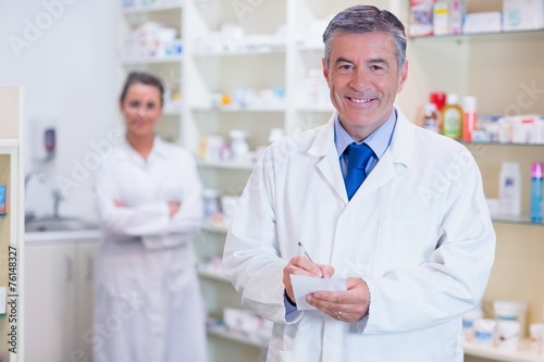 Pharmacist and his trainee with arms crossed behind