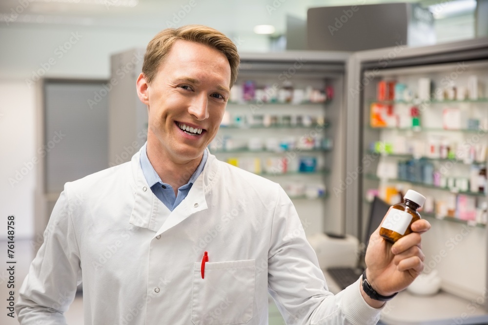 Fototapeta premium Handsome pharmacist holding medicine jar