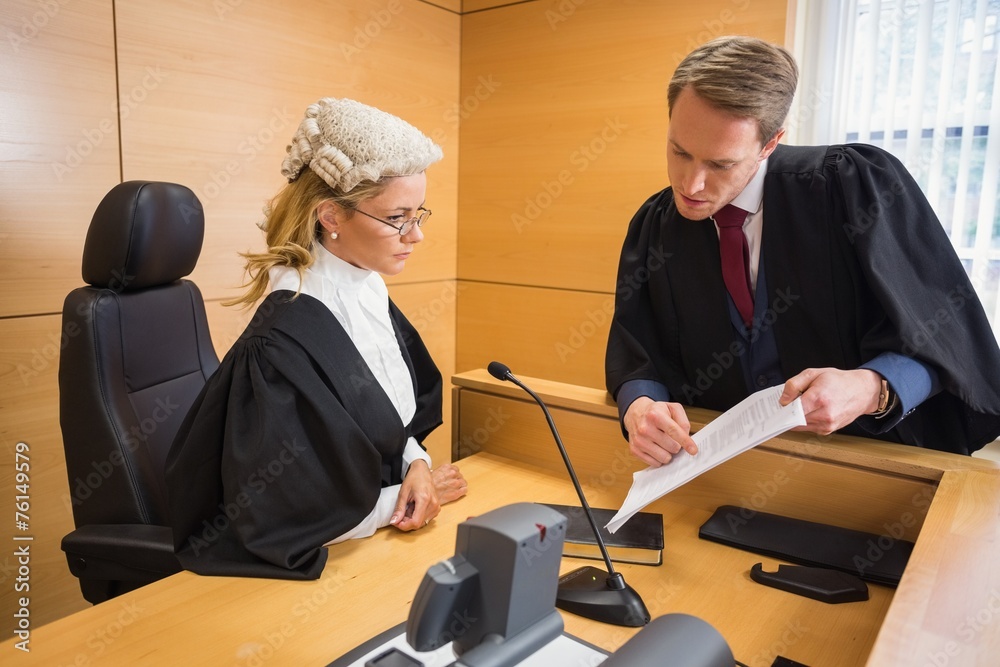 Lawyer speaking with the judge Photos | Adobe Stock