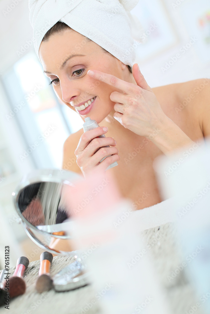 Beautiful woman applying moisturizing cream on her face Beautiful woman applying moisturizing cream on her face