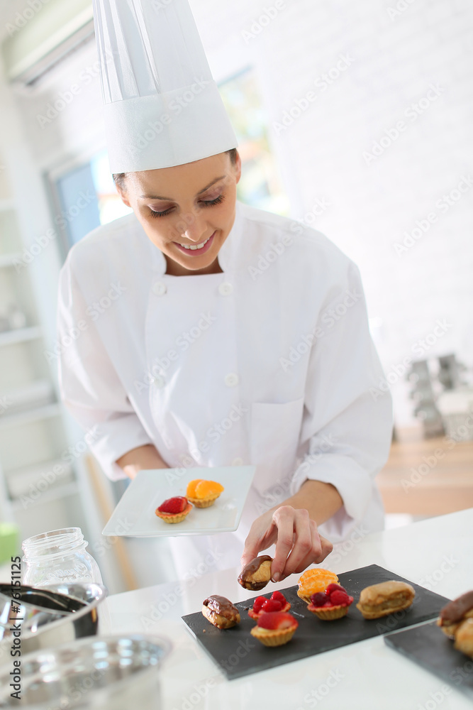 Pastry-cook preparing plate of cake bites Pastry-cook preparing plate of cake bites