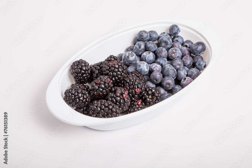 Blackberries and Blueberries in White Dish on White Background Blackberries and Blueberries in White Dish on White Background