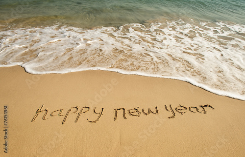 happy new year written in the sand